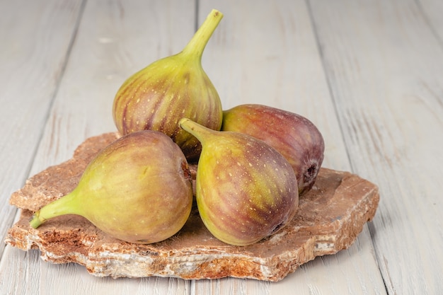 Fichi freschi, leggeri e sani su fondo di legno bianco.