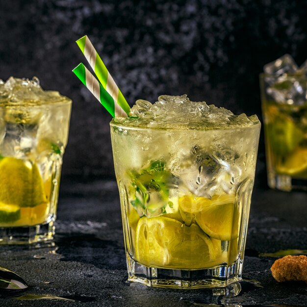 Cocktail di lime fresco con ghiaccio su oscurità.