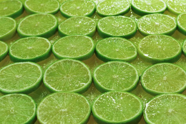 Fette di lime fresche come sfondo.