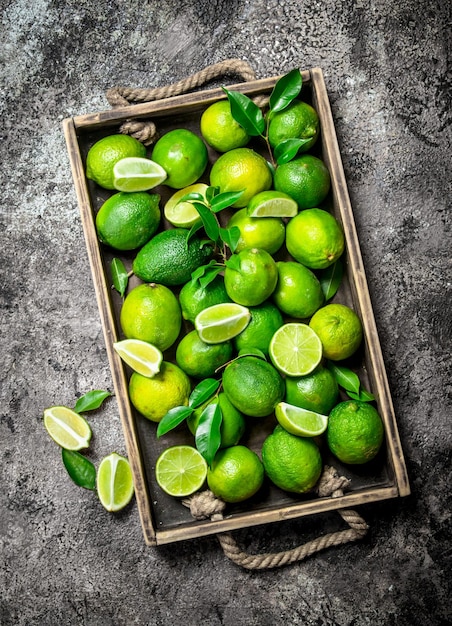 Foto lime fresco e fette di lime maturo sul vassoio