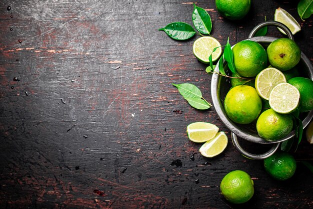 Photo fresh lime with leaves in a colander