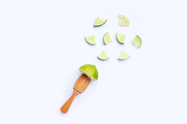 Fresh lime with wooden juicer on white background Copy space