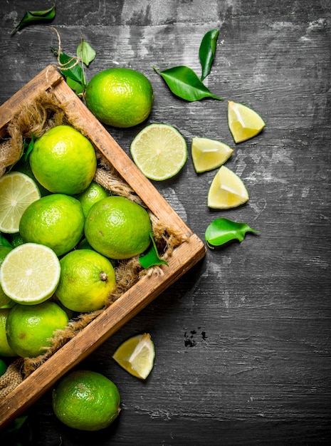 Fresh limes in the old box on a black chalkboard