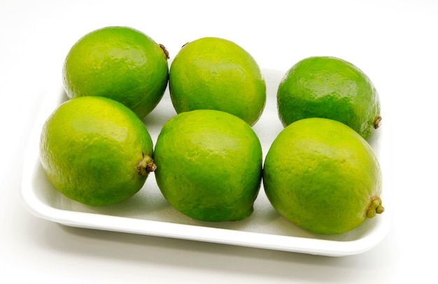 Fresh limes on white surface