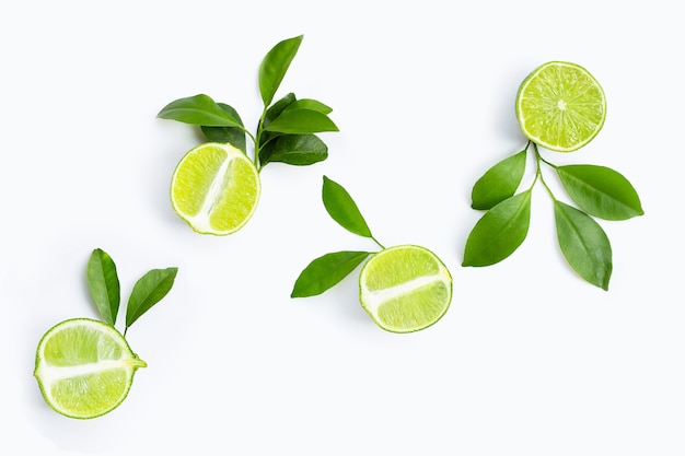 Fresh limes with green leaves on white background. Top view