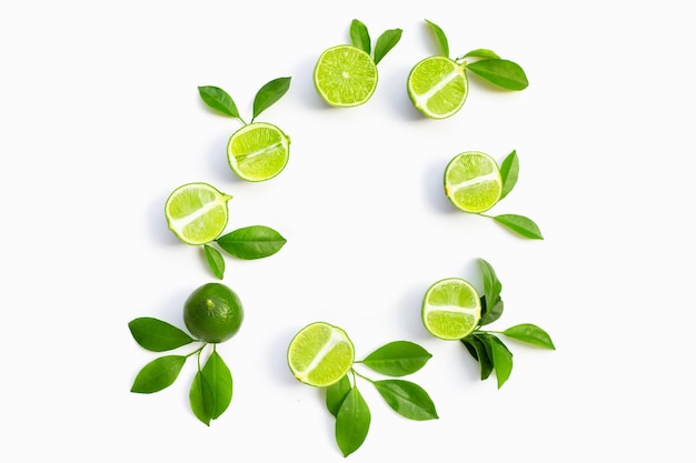 Fresh limes with green leaves on white background