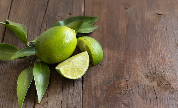 Fresh limes with leaves  on a  wooden table