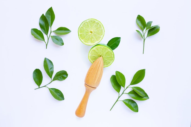 Fresh limes with wooden juicer on white background. 