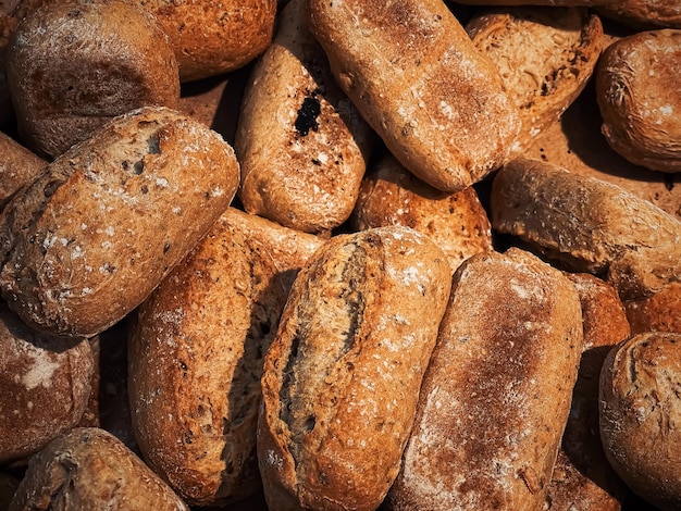 Fresh loaves of bread and buns in rustic bakery baked goods on rustic background and countryside food market