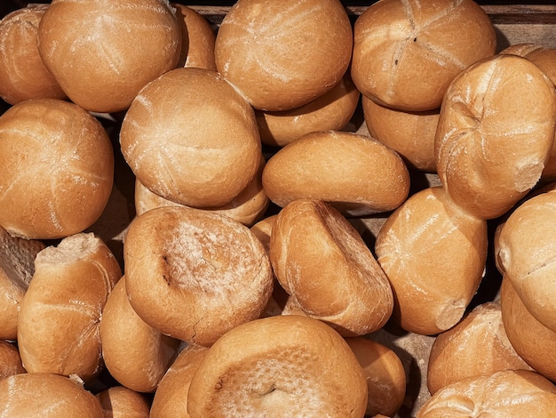 Fresh loaves of bread and buns in rustic bakery baked goods on rustic background and countryside food market