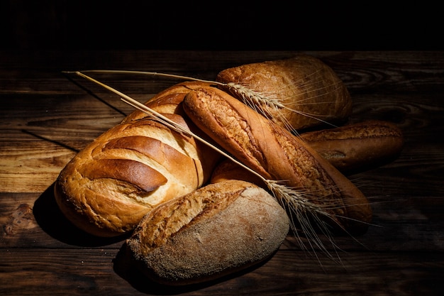 Foto pagnotte fresche di pane con grano e glutine su un tavolo di legno