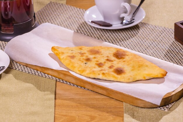 Fresh lobiani and khachapuri on a wooden table in organic packaging. Traditional Georgian pastries and food.