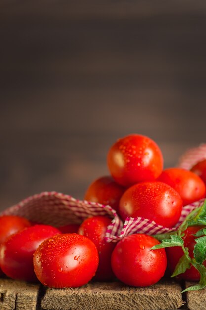 Fresh long plum tomatoes with red checkered kitchen towel