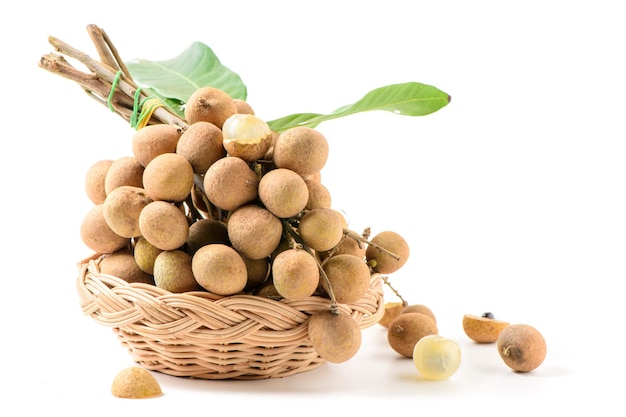 Fresh longan fruit with leaves in bamboo basket isolated on white background,