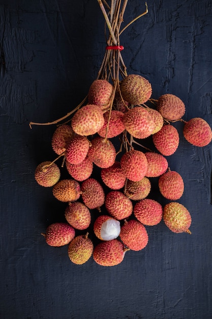 Fresh lychee fruit on a black wooden table