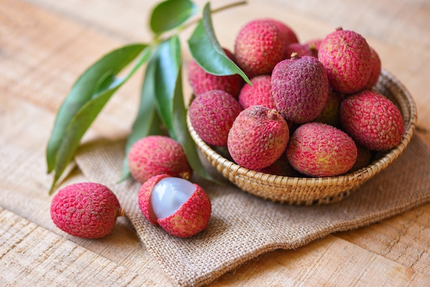 Photo fresh lychee with green leaves in a basket