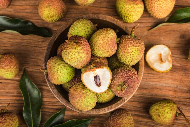 Photo fresh lychees on a wooden board background