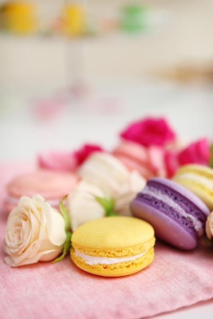 Fresh macaroons and roses on the table indoors