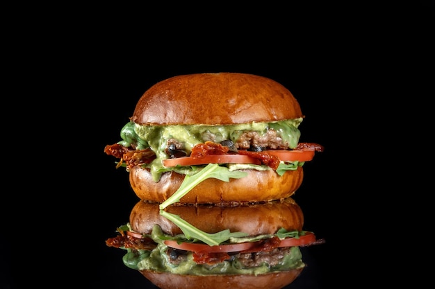 Fresh made Ciabatta Burger with sundried olives tomatoes pesto and beef patty On a black isolated