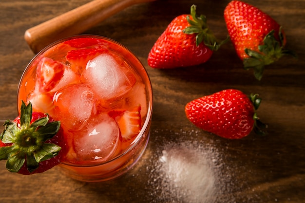 Fresh made Strawberry Caipirinha on wooden background