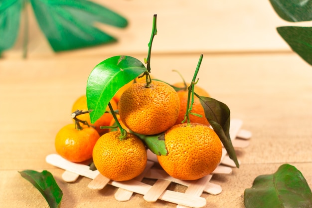 Fresh mandarin orange with leaf on wooden on white background