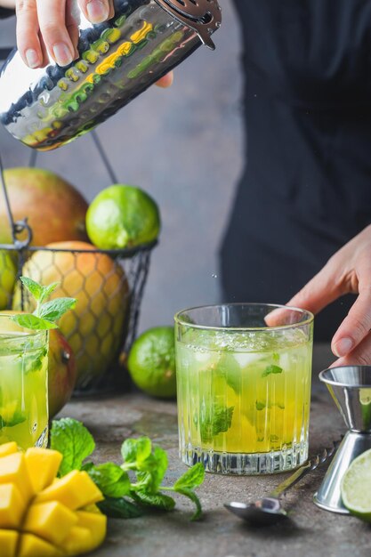 Fresh mango mojito cocktail with lime and mint in a glass