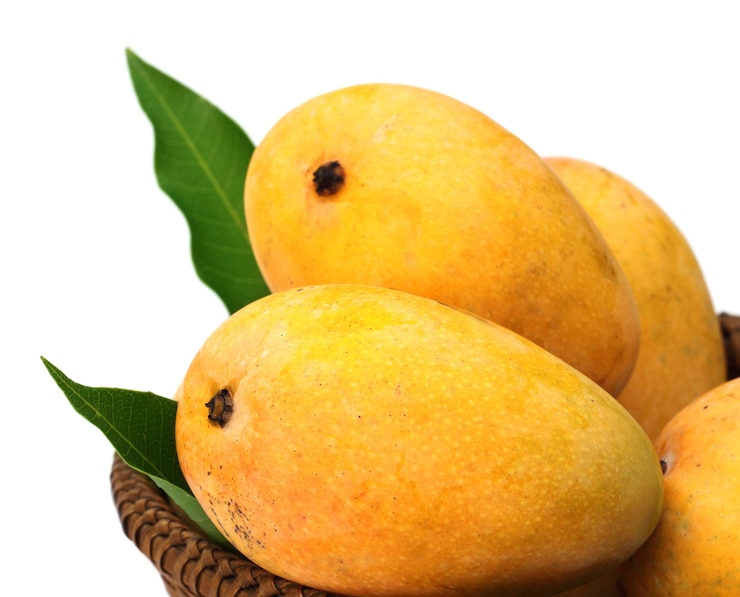 Photo fresh mangoes with green leaves on a basket