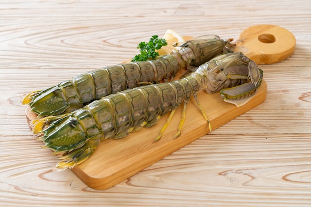 fresh mantis shrimp with lemon on wood board