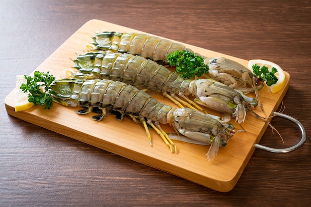 fresh mantis shrimp with lemon on wood board