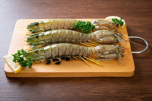 Fresh mantis shrimp with lemon on wood board