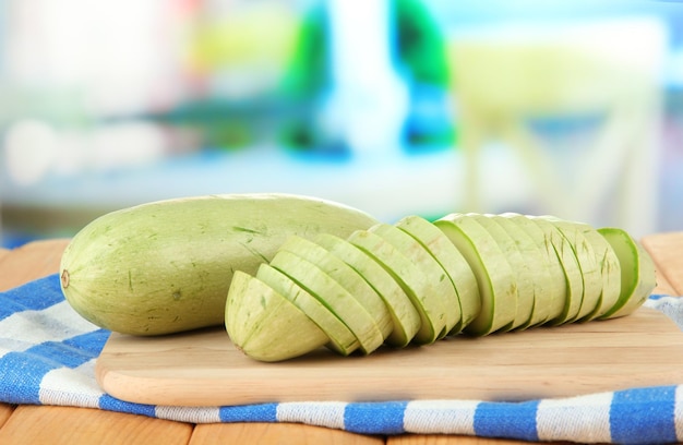 Fresh marrows on cutting board on wooden table on bright background