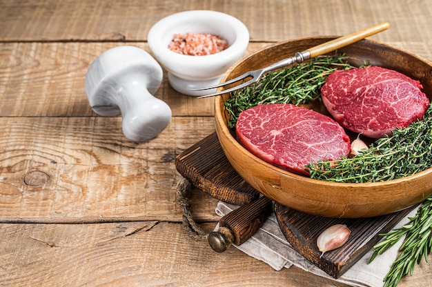 Fresh meat Fillet Mignon steaks from beef tenderloin. wooden background. Top view. Copy space.