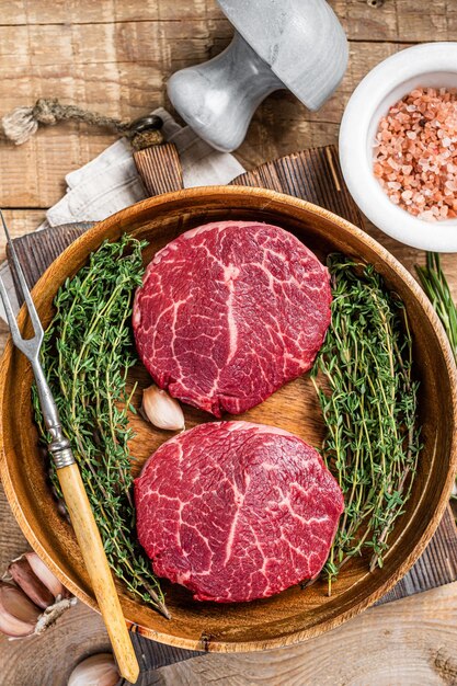 Fresh meat Fillet Mignon steaks from beef tenderloin. wooden background. Top view.