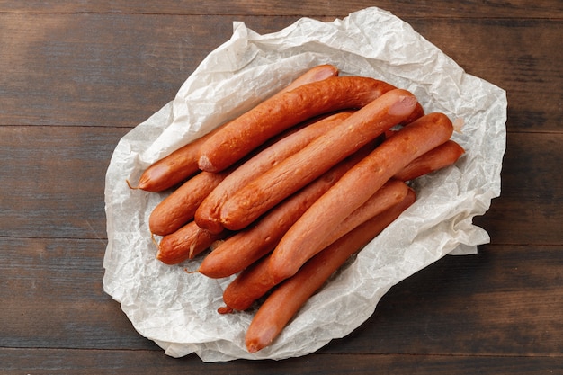 Fresh meat sausages on brown wooden table