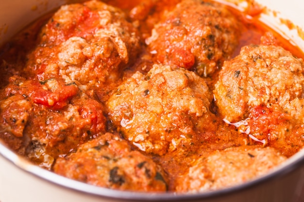 Fresh meatballs under tomato sauce close up