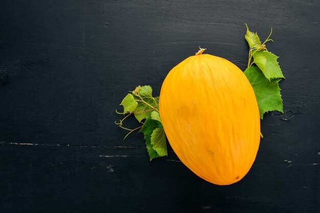 Fresh melon Sliced to pieces of melon On a black wooden background Free space for text Top view