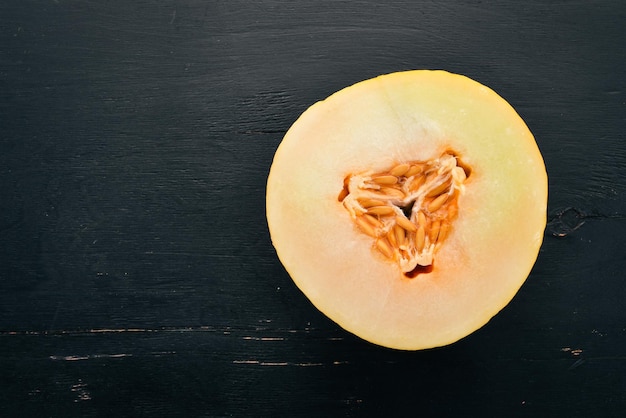 Fresh melon Sliced to pieces of melon On a black wooden background Free space for text Top view