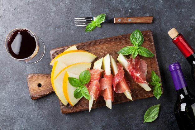 Foto melone fresco con prosciutto e basilico