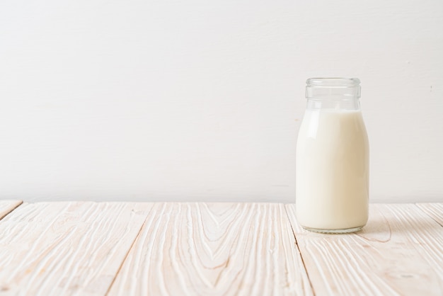 fresh milk in bottle on wood background