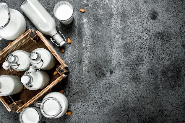 Fresh milk in bottles and jugs with a wooden box.