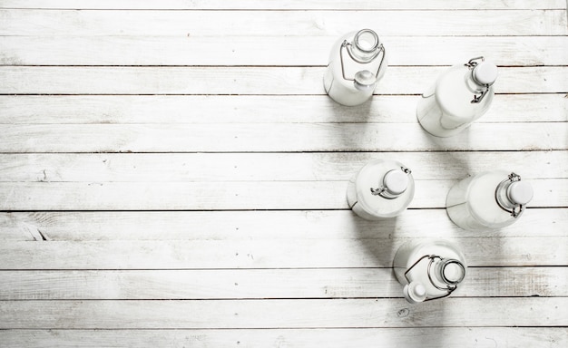 Fresh milk in bottles  on white wooden table.