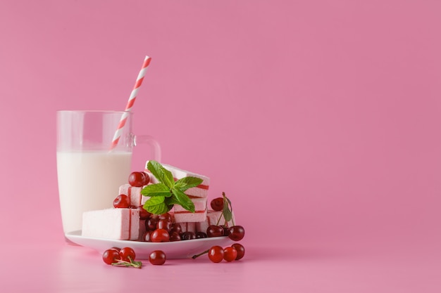 Latte fresco, bevanda alla ciliegia sul tavolo rosa, cocktail proteici assortiti con frutti di bosco freschi