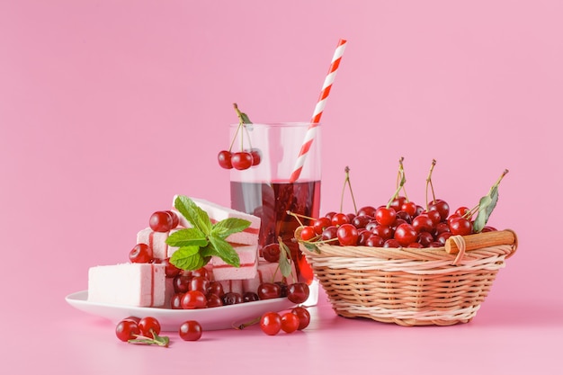 Fresh milk, cherry drink on pink table, assorted protein cocktail with fresh berries