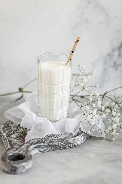 Latte fresco in vetro sulla tavola di legno su sfondo grigio, stile di vita mattutino del villaggio