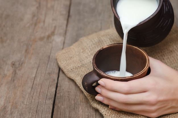 Fresh milk pouring in a clay cap.