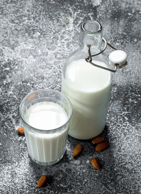 Fresh milk with almonds on rustic table.