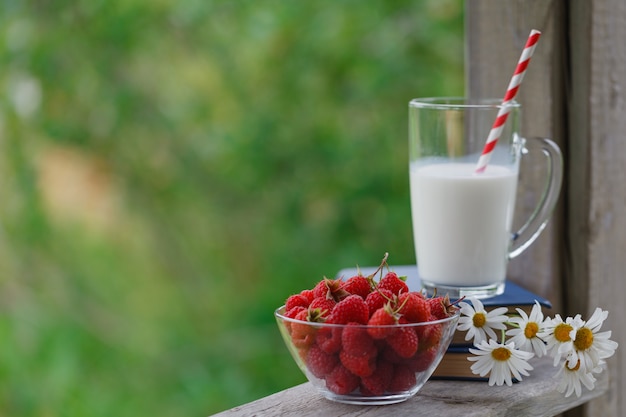 Fresh milk on wooden table with berries