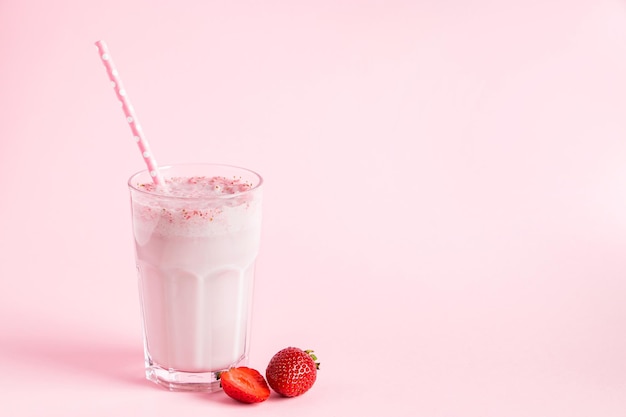 Fresh milkshake with strawberries on pink background Summer detox drink Place for text