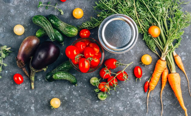 Fresh mini vegetables including fresh carrots baby cucumbers and eggplants jar with cherry tomato