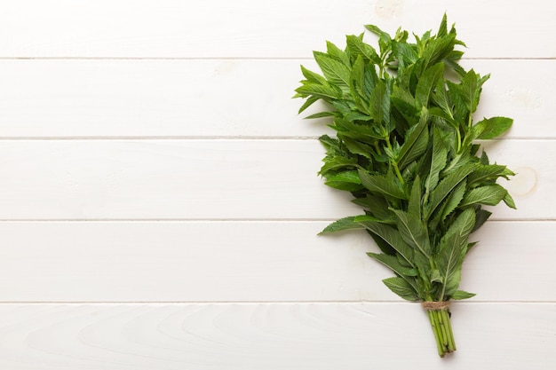 Fresh mint bunch on colored table Top view with copy space